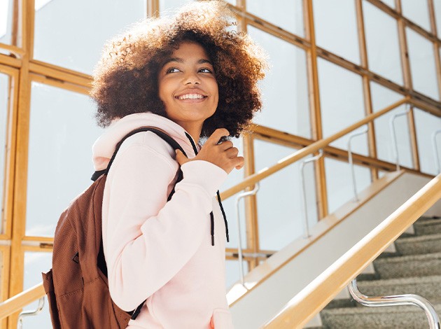 Teen girl smiling while walking on campus
