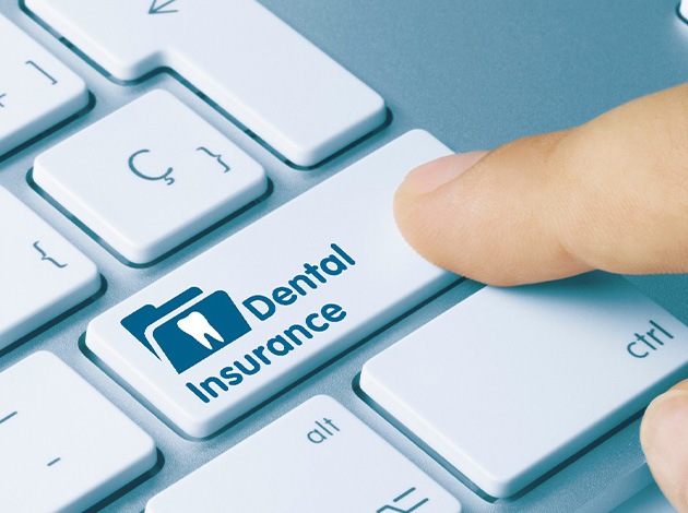 Finger pressing “Dental insurance” button on keyboard