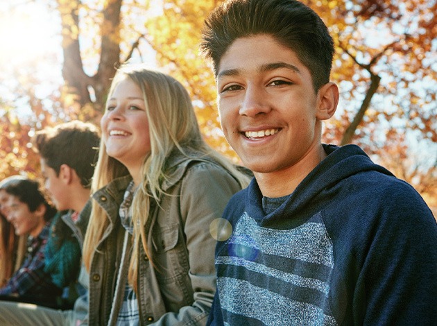 Teens smiling while sitting outside