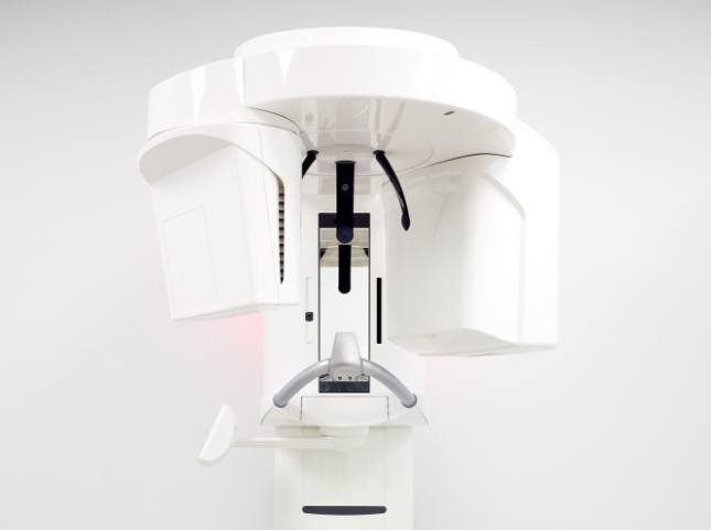 3 D cone beam scanner standing against white wall
