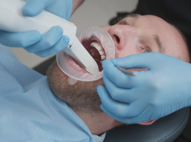 Dentist using a scanner on a patients teeth