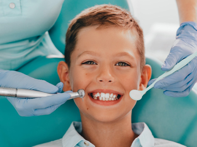 A boy getting his teeth cleaned by a dentist