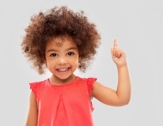 Smiling child pointing their index finger upwards