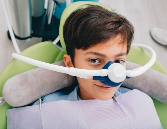 Boy in dental chair wearing nitrous oxide mask on his nose
