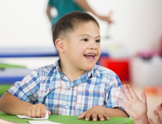 Young boy with special needs sitting at table