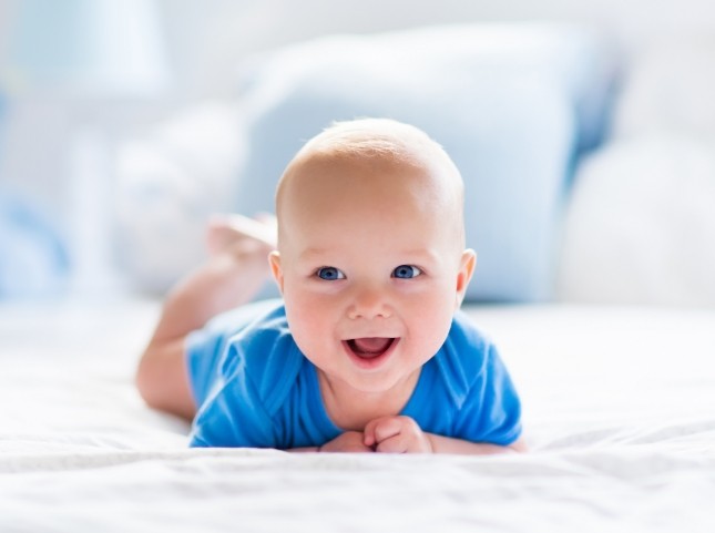 Laughing baby laying on their stomach