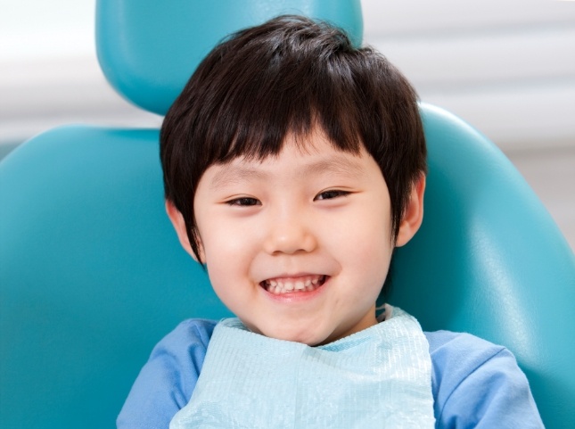 Young boy grinning in dental chair