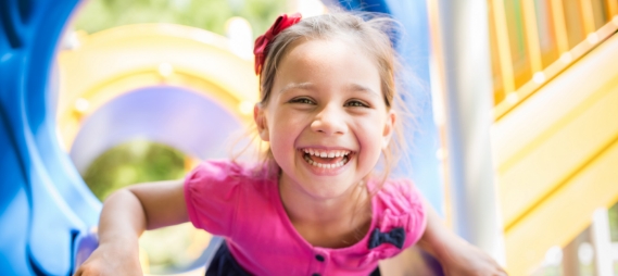 Young girl laughing on outdoor playground