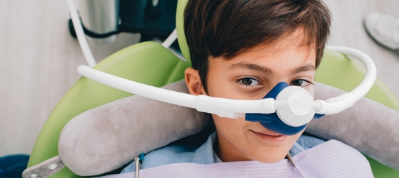 Young boy in dental chair with nitrous oxide mask over his nose