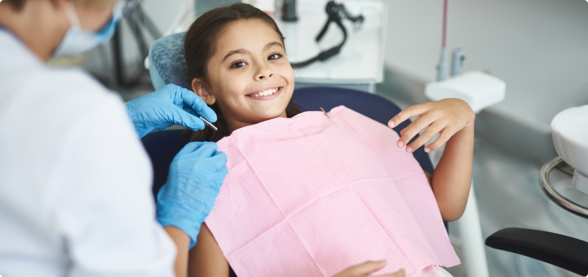 Young girl smiling in dental chair of pediatric dental office in Newark