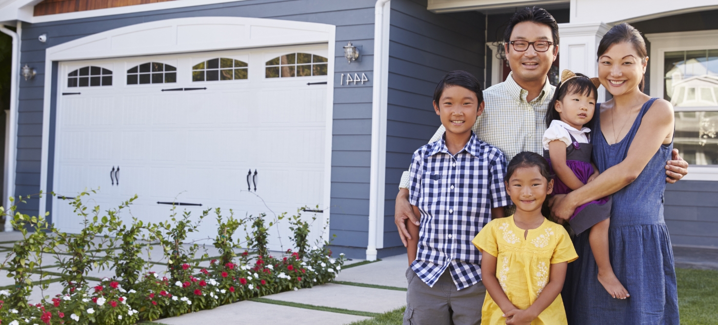 Family of five smiling on their front porch