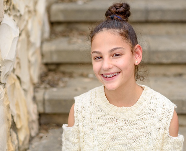 Young girl wearing metal braces and smiling