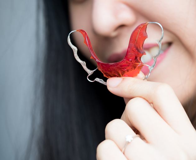 Person holding a removable retainer