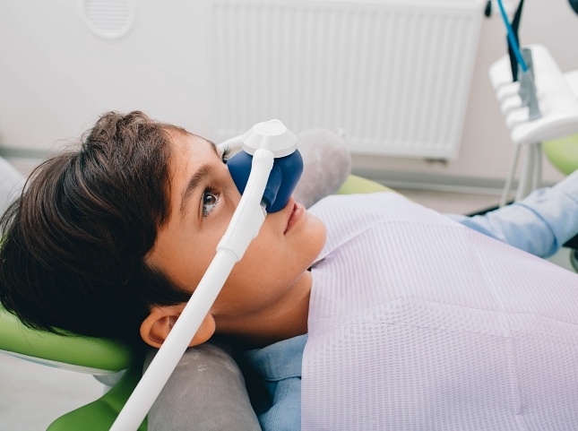 Young boy in dental chair with mask over his nose