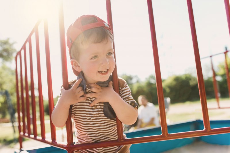 little boy smiling on a playground