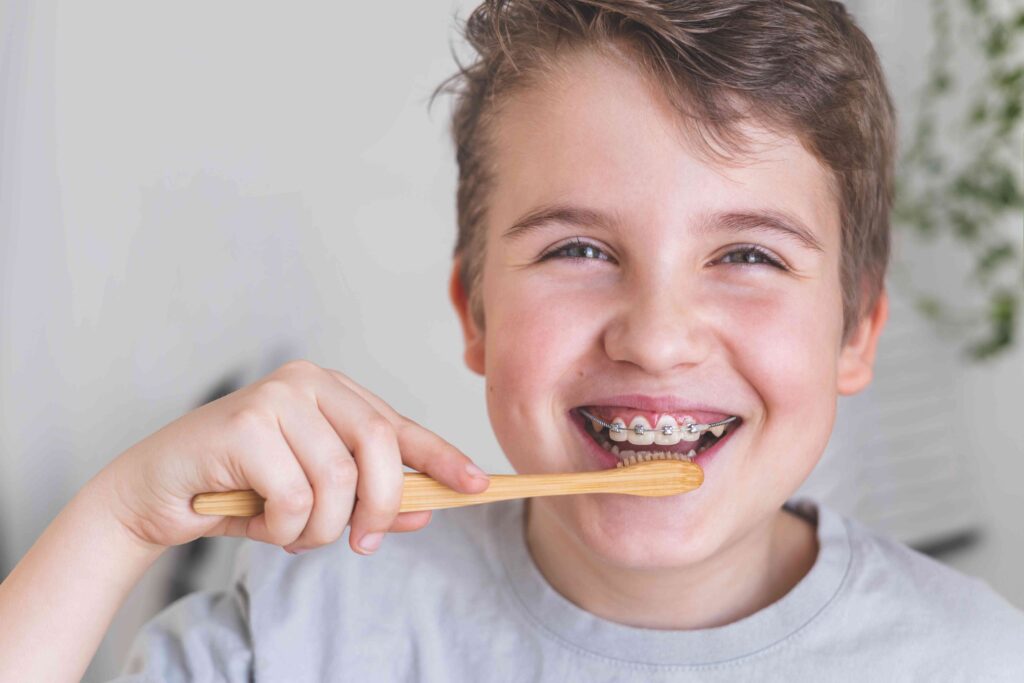 Child brushing his teeth with braces